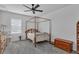 Bright bedroom with a wooden four-poster bed, neutral walls, a ceiling fan, and gray carpet at 391 Cabello Dr, Davenport, FL 33837