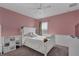 Charming pink bedroom with white wainscoting, a ceiling fan, and a cozy atmosphere at 391 Cabello Dr, Davenport, FL 33837