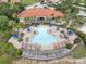 Aerial view of a resort-style pool area with lounge chairs, palm trees, and well-maintained landscaping at 391 Cabello Dr, Davenport, FL 33837