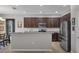 Kitchen boasts a stainless steel refrigerator, granite countertops, dark cabinets, and modern appliances at 391 Cabello Dr, Davenport, FL 33837