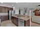 Open kitchen with granite countertops, stainless steel appliances, and a view of the staircase at 391 Cabello Dr, Davenport, FL 33837