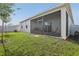 Backyard features a screened lanai, lush lawn, and full white fence at 394 Quayside Ave, Mascotte, FL 34753