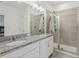 Bathroom featuring a double vanity with granite countertop and tiled shower at 394 Quayside Ave, Mascotte, FL 34753