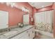 Charming bathroom features granite countertop, white cabinets, dual sinks, and floral shower curtain at 394 Quayside Ave, Mascotte, FL 34753