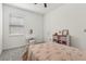 Bright bedroom features gray carpet, ceiling fan, window, and white vanity with cushioned seat at 394 Quayside Ave, Mascotte, FL 34753