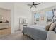 Comfortable bedroom with ceiling fan, illuminated vanity, and two windows at 394 Quayside Ave, Mascotte, FL 34753