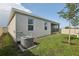 Exterior view of home with screened lanai, lush lawn, and full white fence at 394 Quayside Ave, Mascotte, FL 34753