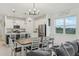 Bright, modern kitchen and dining area with white cabinetry, stainless steel appliances, and view of green fields at 394 Quayside Ave, Mascotte, FL 34753