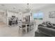 Bright, modern kitchen and dining area with white cabinetry, stainless steel appliances, and stylish lighting fixtures at 394 Quayside Ave, Mascotte, FL 34753