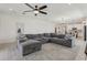 Spacious living room with a comfortable, large gray sectional and neutral patterned rug at 394 Quayside Ave, Mascotte, FL 34753