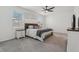 Comfortable main bedroom with neutral decor, a ceiling fan, and a view through the large windows at 394 Quayside Ave, Mascotte, FL 34753