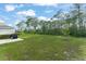 A spacious backyard with healthy green grass, wooded area, and a patio area for outdoor grilling at 3941 Willowbrook Dr, Edgewater, FL 32141