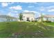 A spacious backyard with healthy green grass and a rear view of the two-story home with solar panels at 3941 Willowbrook Dr, Edgewater, FL 32141