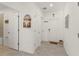 Bright hallway featuring neutral tile, white walls, and decorative artwork, leading to various rooms at 3941 Willowbrook Dr, Edgewater, FL 32141