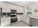 Bright kitchen featuring white cabinets, stainless steel appliances, and stylish backsplash at 3941 Willowbrook Dr, Edgewater, FL 32141