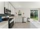 Eat-in kitchen includes stainless steel appliances, white cabinetry, and sliding glass door to the backyard at 3941 Willowbrook Dr, Edgewater, FL 32141