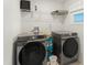 Well-lit laundry room features gray Samsung washer and dryer and white wire shelving for ample storage space at 3941 Willowbrook Dr, Edgewater, FL 32141