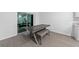 Cozy dining area with a modern table and bench seating, complemented by sleek tiled flooring and natural light at 3977 Willowbrook Dr, Edgewater, FL 32141