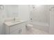 A stylish bathroom features a tub with marble shower and white vanity with a bright, modern design at 404 Famagusta Dr, Davenport, FL 33896