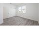 Bright bedroom featuring wood-look floors, a large window, and a closet, creating a modern and comfortable space at 404 Famagusta Dr, Davenport, FL 33896