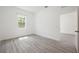 A sunlit bedroom features sleek, modern flooring, a bright window, and an open doorway at 404 Famagusta Dr, Davenport, FL 33896