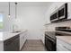 A bright kitchen with stainless steel appliances, pendant lights and quartz countertops at 404 Famagusta Dr, Davenport, FL 33896