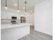 The kitchen features stainless steel appliances, white cabinets, and an island with quartz countertops at 404 Famagusta Dr, Davenport, FL 33896