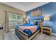Comfortable bedroom features a soft blue quilt and natural-toned furniture with stylish wall decor at 424 Ocean Course Ave, Davenport, FL 33896