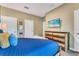 Comfortable bedroom features a soft blue quilt and natural-toned furniture, with a wall-mounted tv at 424 Ocean Course Ave, Davenport, FL 33896