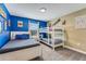 Shared bedroom featuring a bunk bed, twin bed, blue accent wall, and a window at 424 Ocean Course Ave, Davenport, FL 33896