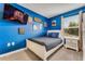 Bright bedroom featuring a blue accent wall, mounted TV, window, and comfortable furnishings at 424 Ocean Course Ave, Davenport, FL 33896