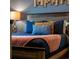 Bedroom with blue bedding, rustic wood headboard, and decor at 424 Ocean Course Ave, Davenport, FL 33896