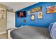 Cozy bedroom showcasing a blue accent wall, mounted TV, and comfortable furnishings at 424 Ocean Course Ave, Davenport, FL 33896
