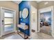 Stylish entryway with a blue accent wall, modern console table, and a view of bedroom and bathroom at 424 Ocean Course Ave, Davenport, FL 33896
