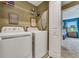 Practical laundry room featuring a washer and dryer, storage shelf, and access to a bedroom at 424 Ocean Course Ave, Davenport, FL 33896