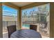 Covered patio seating area with view of screened-in pool and backyard at 424 Ocean Course Ave, Davenport, FL 33896