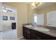 Bathroom boasts double sinks, granite countertops, and a large mirror for a luxurious feel at 4265 Foxhound Dr, Clermont, FL 34711