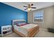 Bedroom with a large window, ceiling fan and bed with a blue accent wall at 4265 Foxhound Dr, Clermont, FL 34711