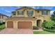 Charming two-story home featuring a three-car garage, beautiful green shutters, and a brick driveway at 4265 Foxhound Dr, Clermont, FL 34711