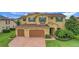 Charming two-story home featuring a three-car garage, beautiful green shutters, and a brick driveway at 4265 Foxhound Dr, Clermont, FL 34711