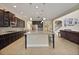 Spacious kitchen with dark wood cabinetry, stone countertops, tile backsplash, and an island for additional seating at 4265 Foxhound Dr, Clermont, FL 34711
