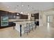 Spacious kitchen featuring dark wood cabinetry, a large granite island with seating, and stainless steel appliances at 4265 Foxhound Dr, Clermont, FL 34711