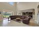 Open-concept living room with a soaring ceiling, leather furniture, and access to the kitchen and outdoor patio at 4265 Foxhound Dr, Clermont, FL 34711