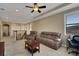 Comfortable living room with couches, a ceiling fan and stair access to upper level at 4265 Foxhound Dr, Clermont, FL 34711