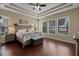 Comfortable main bedroom featuring a tray ceiling, hardwood floors, and plenty of natural light at 4265 Foxhound Dr, Clermont, FL 34711