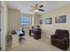 Home office featuring a ceiling fan, large window, artwork, glass top table, and comfortable chair at 4265 Foxhound Dr, Clermont, FL 34711