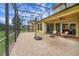 Covered patio with brick floors, comfortable wicker furniture, a fan overhead and a basketball hoop at 4265 Foxhound Dr, Clermont, FL 34711
