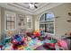 Cozy playroom with a trey ceiling, large arched window, hardwood floors, and an assortment of toys at 4265 Foxhound Dr, Clermont, FL 34711