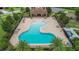 Aerial view of a community pool and sundeck with ample seating and palm trees at 4265 Foxhound Dr, Clermont, FL 34711