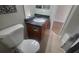 Bathroom features a toilet and sink with a dark countertop and tan tile flooring at 445 Fountainhead Cir # 262, Kissimmee, FL 34741